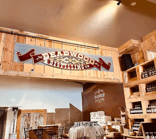 Interior view of Full Throttle Distillery in Deadwood featuring rustic decor, merchandise, and local spirits display.