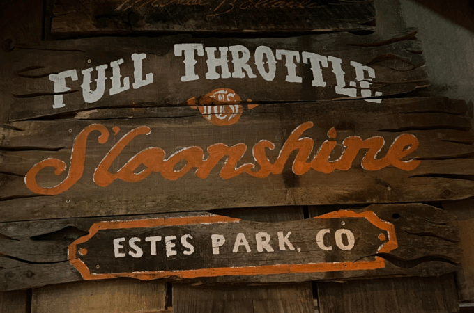 Rustic wooden Full Throttle Moonshine sign at Estes Park, highlighting a must-see stop on any list of what to visit in Estes Park.