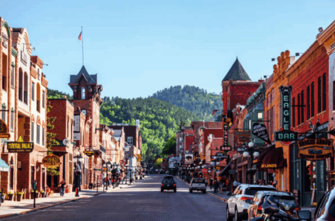 Historic Main Street in Deadwood, South Dakota filled with shops, bars, and visitors — a popular destination for those searching what to do in Deadwood