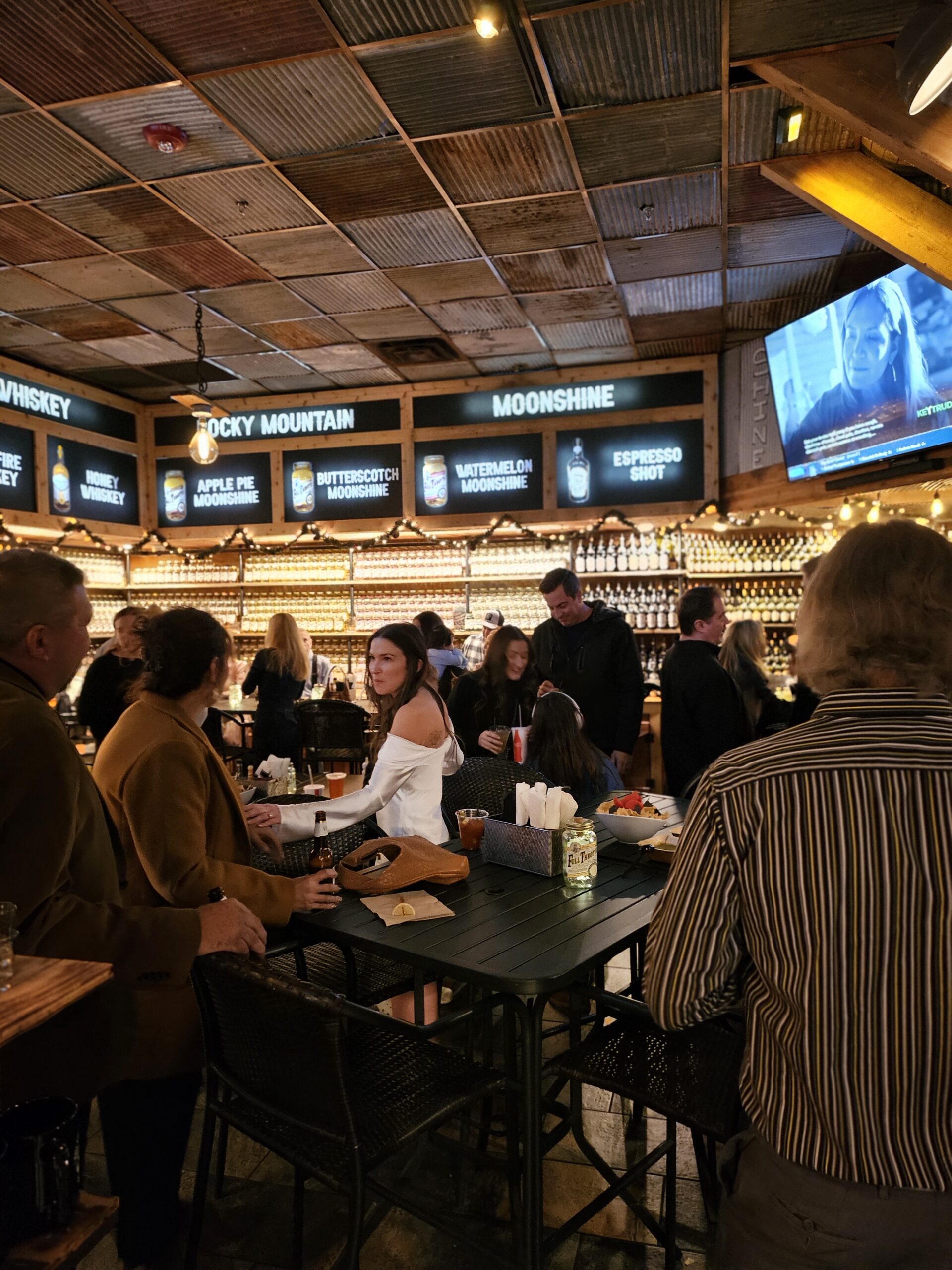 Couples and groups enjoying craft drinks at Full Throttle Distillery Smoke House & Grill in Estes Park—perfect for unique date nights.