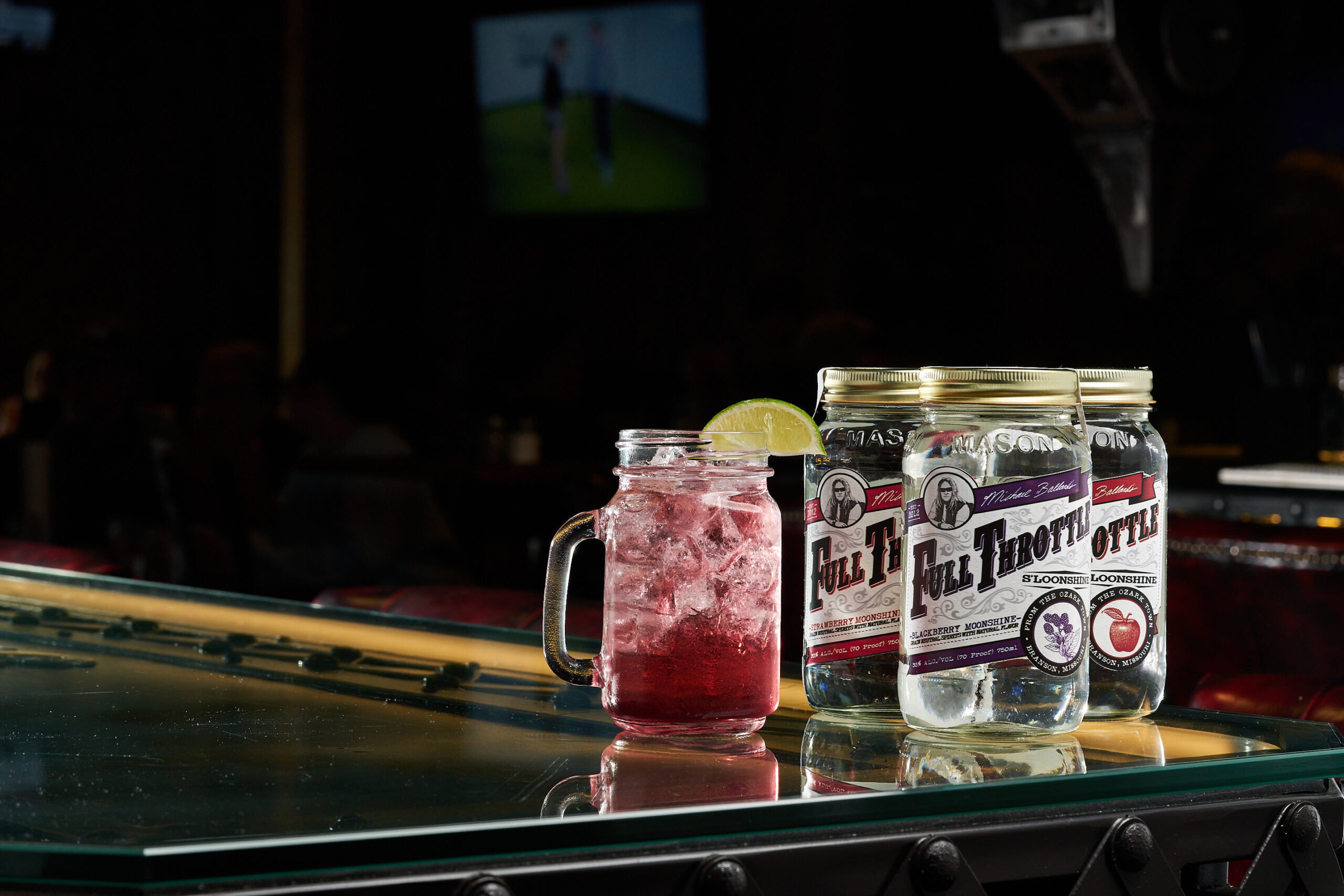 Moonshine cocktail with lime and Full Throttle flavored moonshine jars on a bar in Estes Park