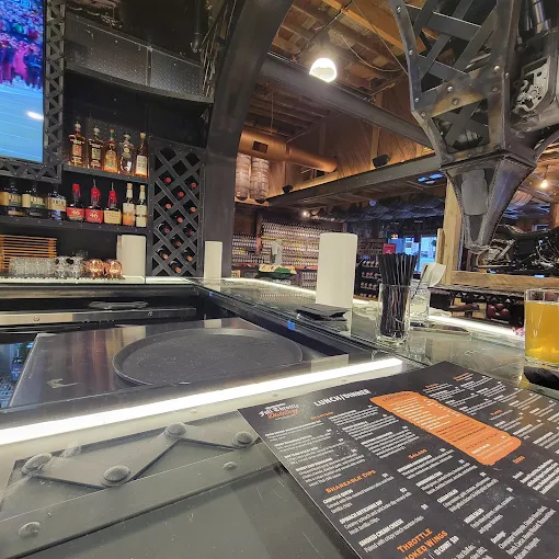 Interior bar at Full Throttle Distillery Branson, showcasing spirits and a menu for whiskey tasting and dining.