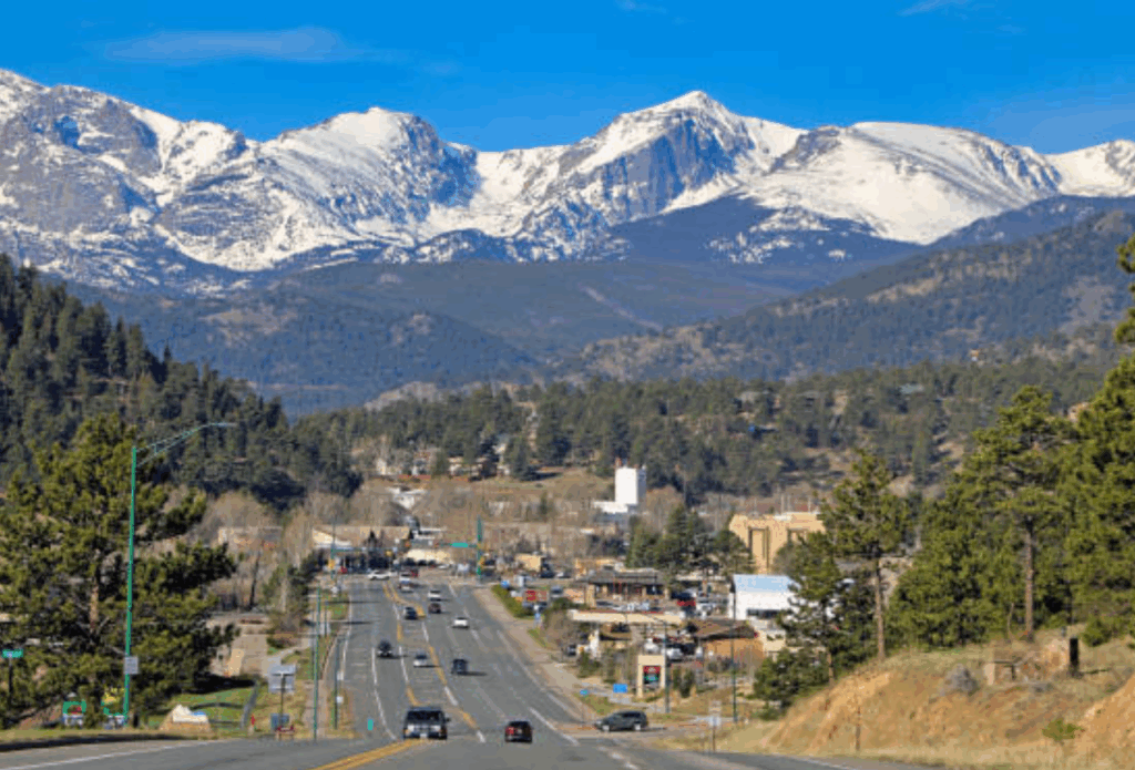 Scenic drive into Estes Park with snow-capped Rocky Mountains in the background, a beautiful start to an Estes Park Day Trip.