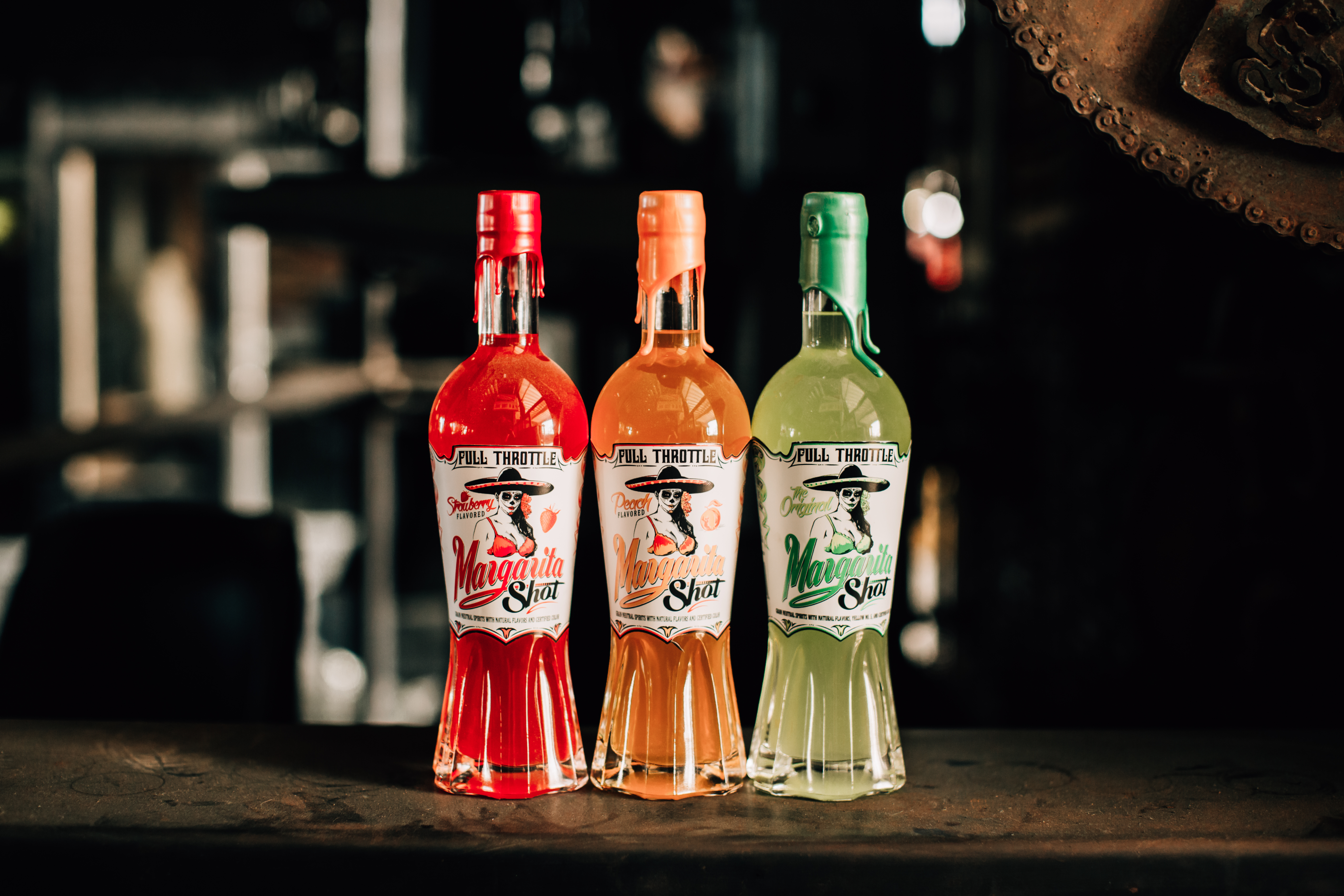 Full Throttle Margarita Shots trio of Strawberry, Peach, and Original flavors lined up on a bar.