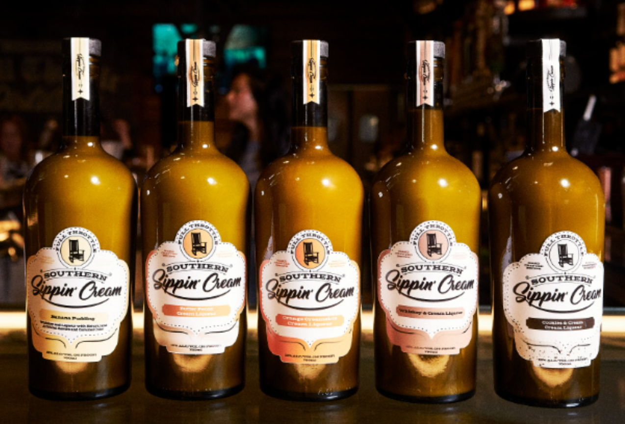A lineup of five bottles of Full Throttle sippin cream, including Banana Pudding, Butter Pecan, Orange Creamsicle, and Cookies & Cream flavors.