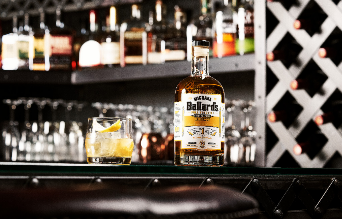 A bottle of Michael Ballard's Full Throttle Whiskey next to an Old Fashioned cocktail, representing our Special Spirits.