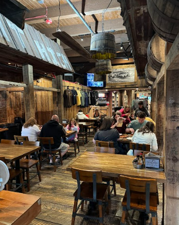 Rustic indoor dining area with exposed brick, murals, and wooden tables, suitable for a comfortable Plan Your Wedding at Estes Park event