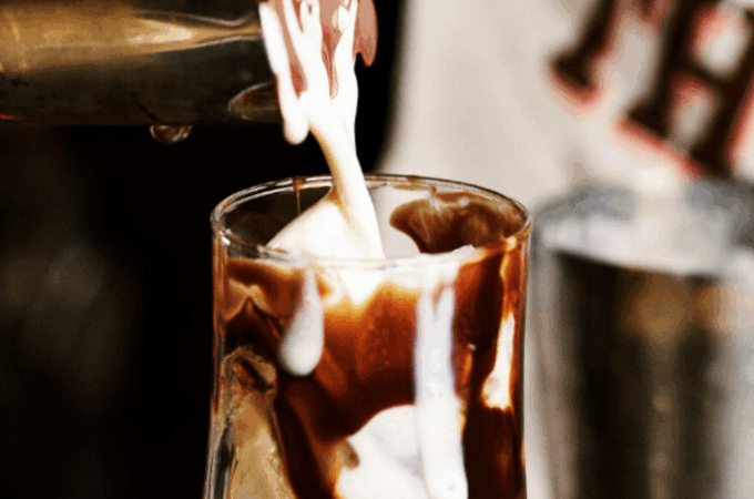 Creamy cocktail being poured into a chocolate-drizzled glass at a bar in Deadwood – Plans in Deadwood