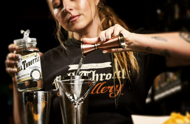 A bartender crafting a signature cocktail with S'Loonshine, a key part of the Deadwood Distilling Story.